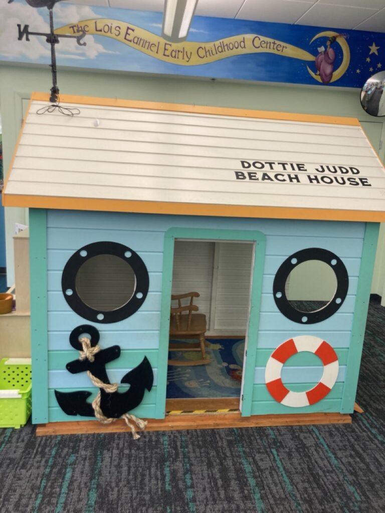 playhouse at the palm harbor library children's room that is beach house themed