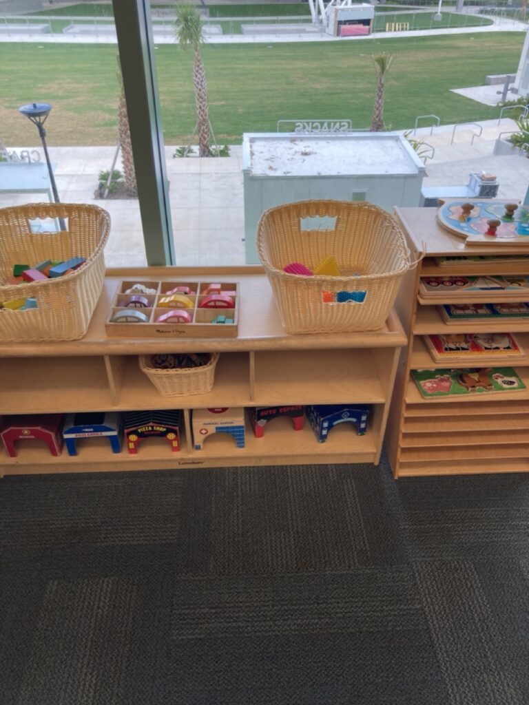 toy shelf at the clearwater library main branch showing puzzles and wooden cars