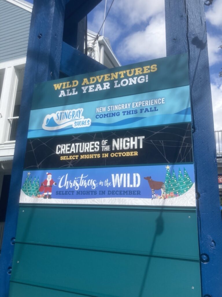 Sign at the entrance of ZooTampa showing the upcoming holiday events, including Halloween and Christmas light events
