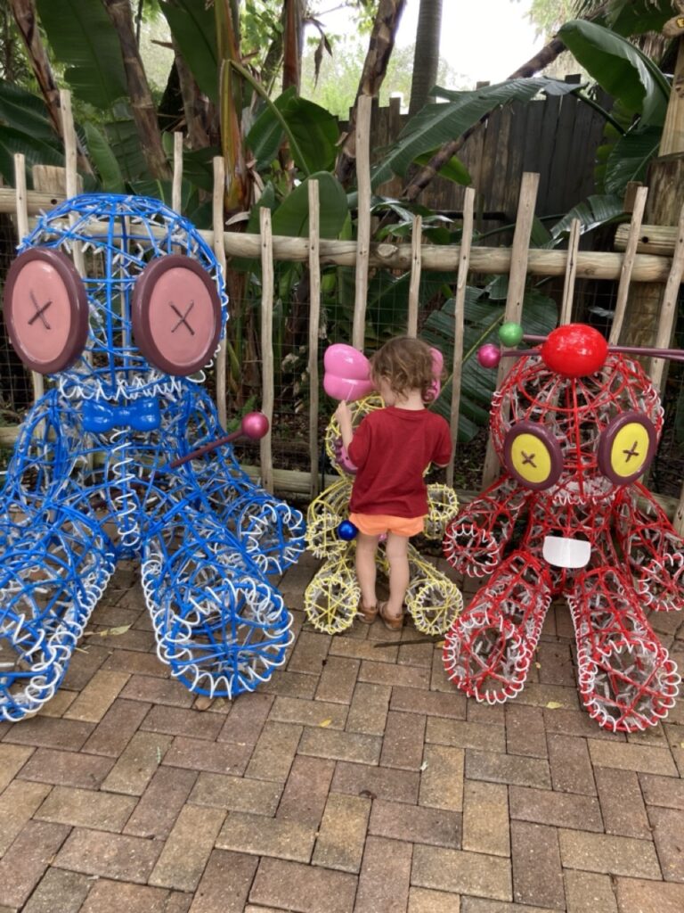 Zootampa Creatures of the Night decorations with a toddler standing between two metal creepy ragdolls