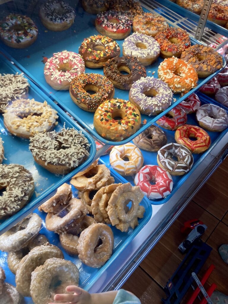 donut display with two shelves of donuts on blue trays