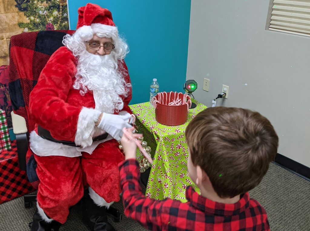 Toddler being handed a candy cane from Santa