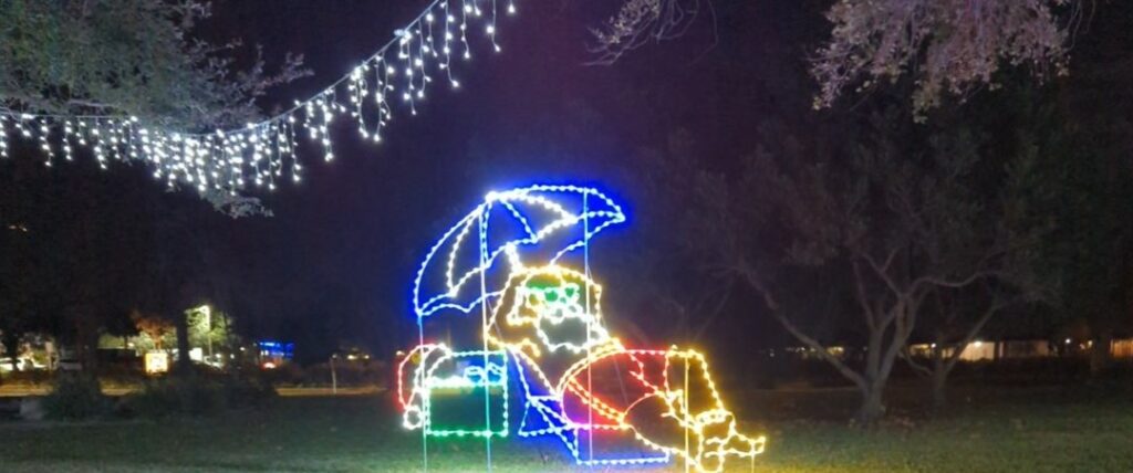 Christmas lights in the shape of Santa relaxing at the beach