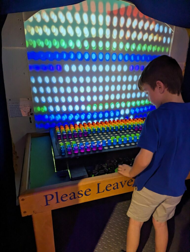 a child standing in front of a giant light bright