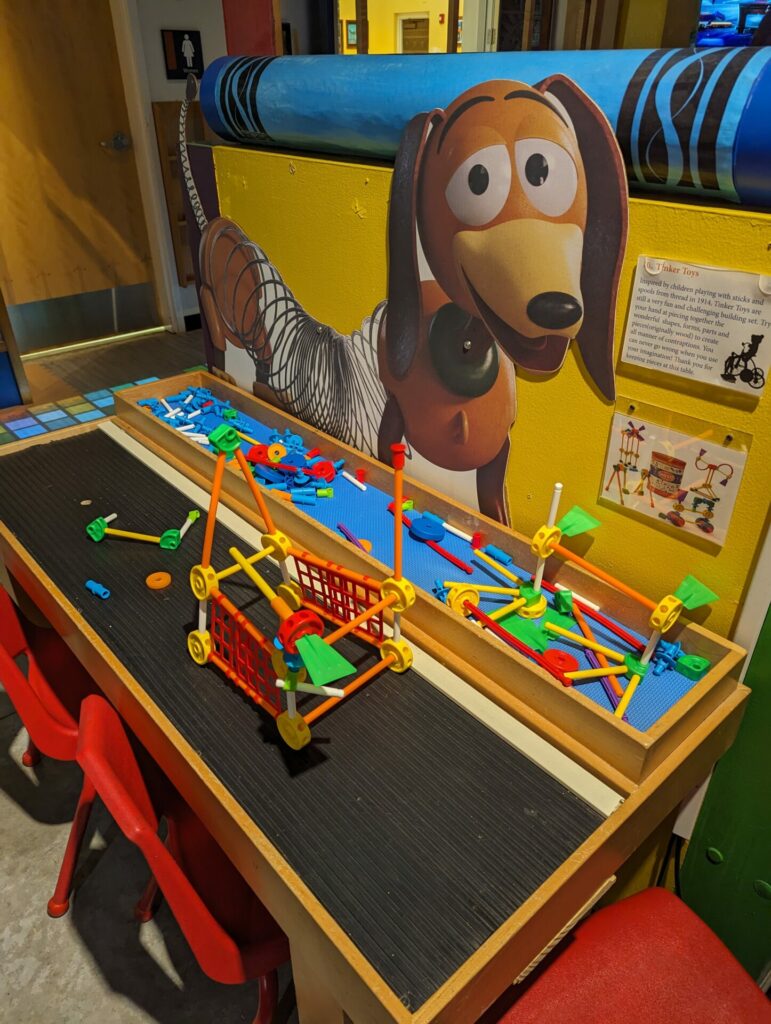 a table with slinky dog in the background and a toy connector set being assembled on the table