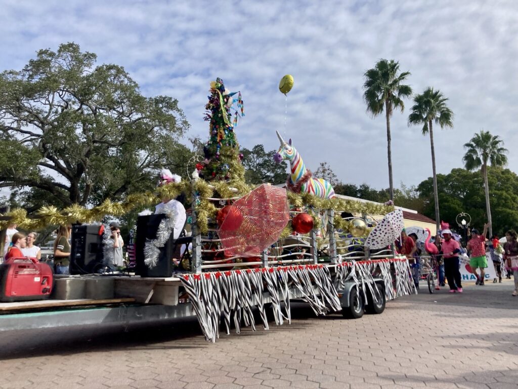 a funky christmas parade float with a christmas tree and unicorn at the safety harbor holiday parade