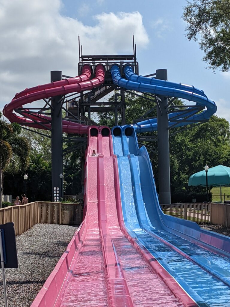a tunnel water slide with two red slides and two blue sides side by side