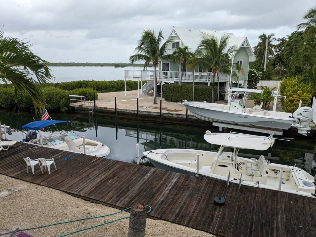 two white boats on house docks in the Florida keys