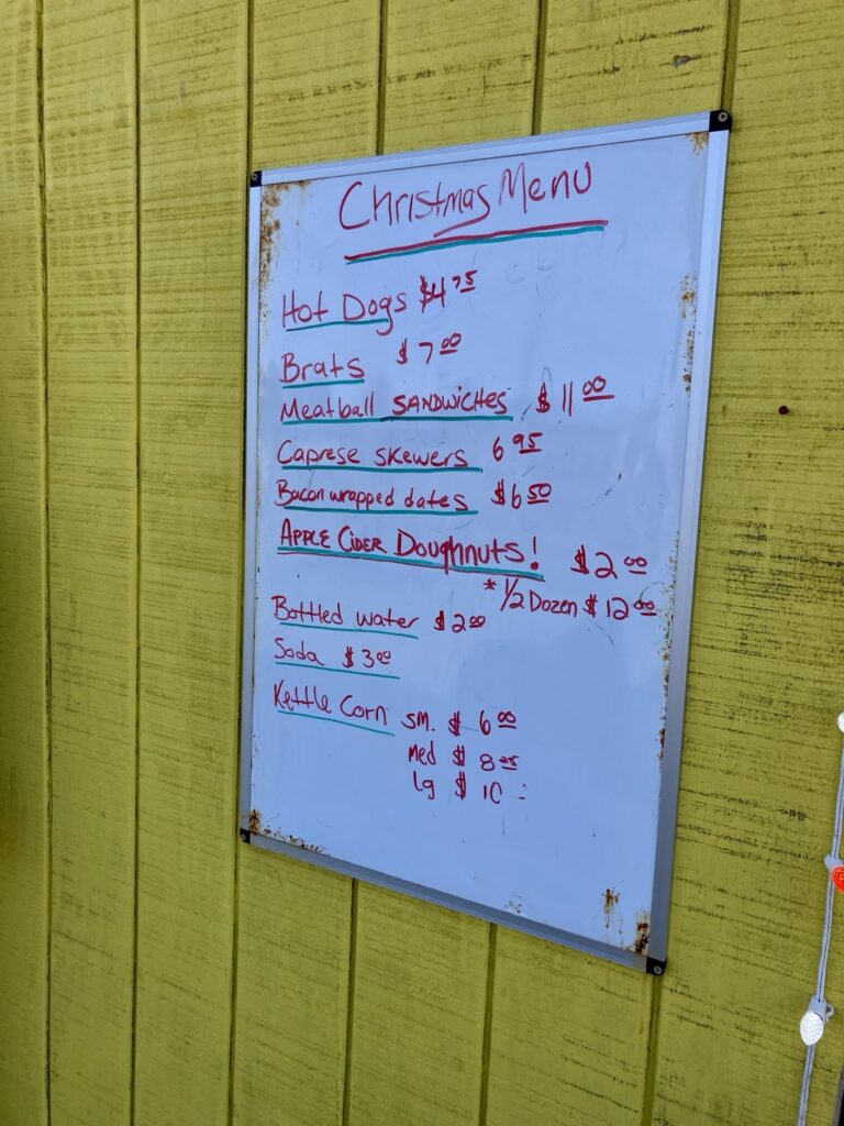 a white board sign that says christmas menu with food items listed on it
