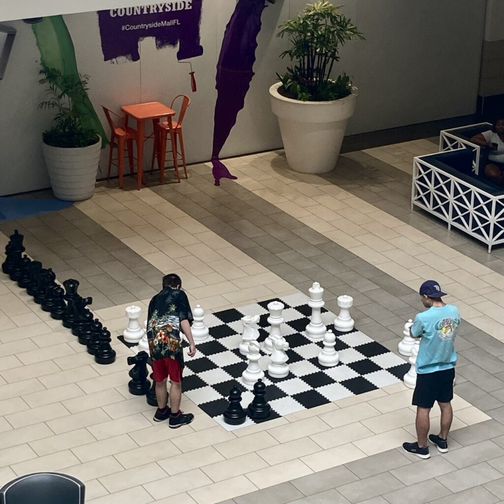 aerial view of a big oversize chess board with two people playing