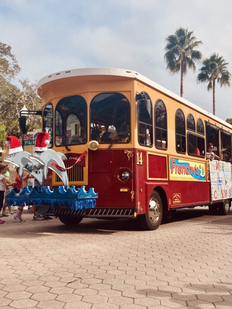 Clearwater's jolly trolley car decorated with dolphins wearing Santa hats