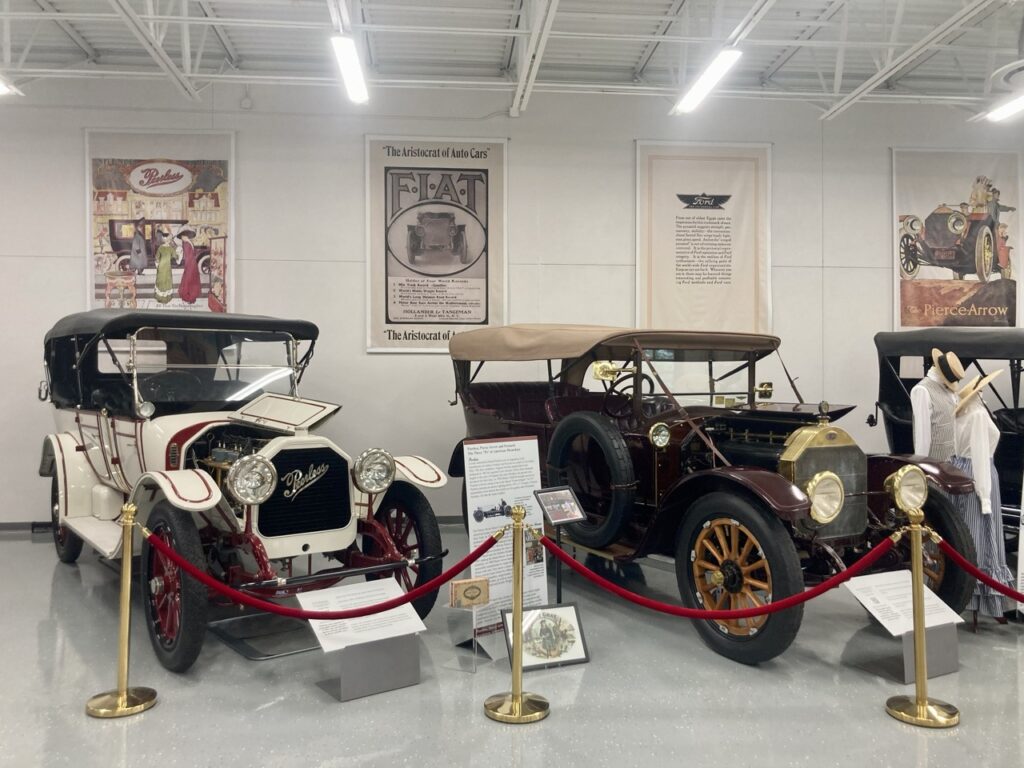 Two very old cars, one black and one white, on display at the Palmetto Collection in Clearwater