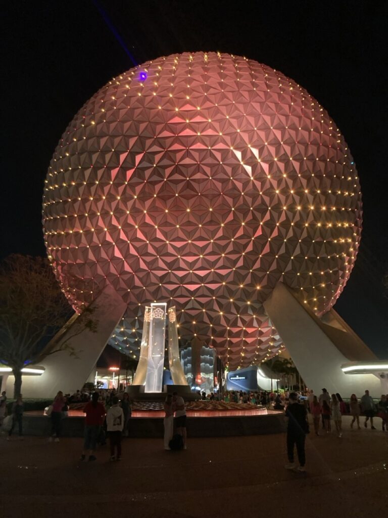 epcot ball at night light up in a peach color