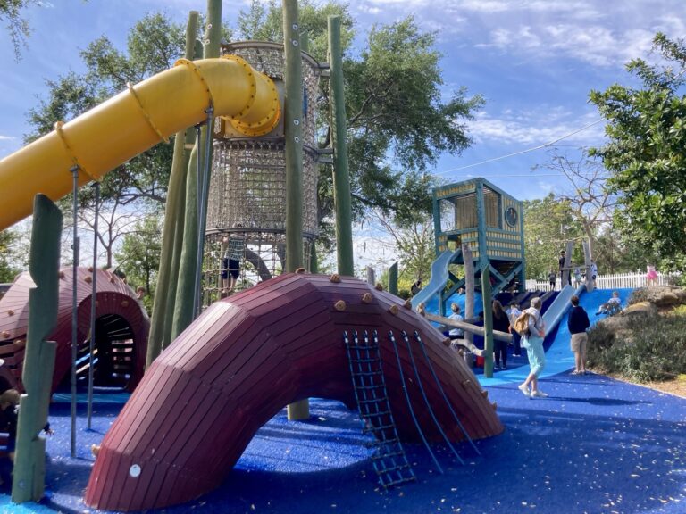 glazer park playground at st. pete pier with a big yellow slide in the background and a climbing tube structure in the foreground