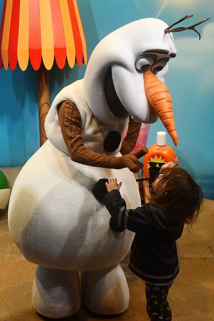 toddler trying to touch olaf's nose at hollywood studios