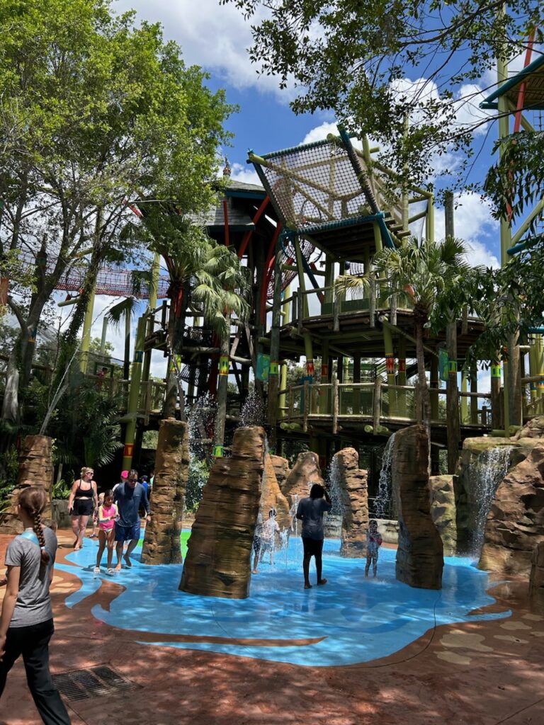 Picture of busch gardens oasis area with splash pad in front and climbing area in the back